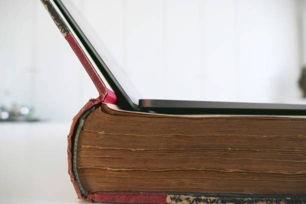 istock Vintage book side view and a laopto lying on top 825593792