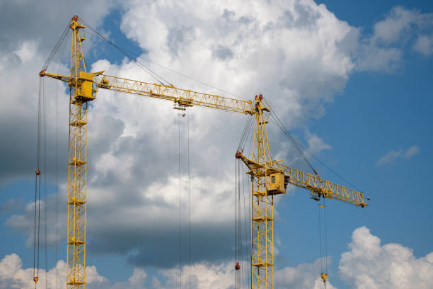 istock Tower crane on a background of clouds 825593900