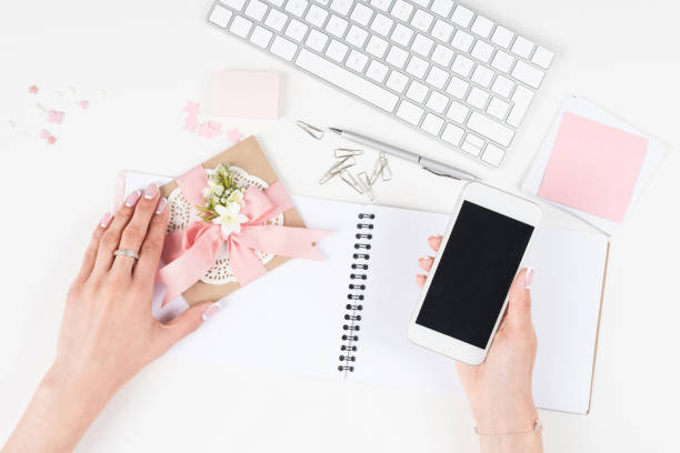 istock female hands holding decorative envelope and smartphone with blank screen 825597720