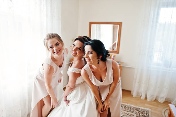 istock Fabulous young bride posing with her bridesmiads in her room on the wedding day. 825600442