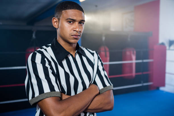 Portrait of confident male referee with arms crossed Portrait of confident male referee with arms crossed against boxing ring boxing referee stock pictures, royalty-free photos & images