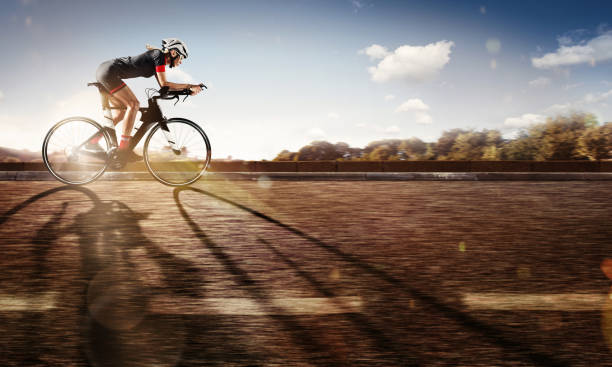 スポーツ。サイクリストは日没時彼の自転車に乗る。劇的な背景。 - road biking ストックフォトと画像