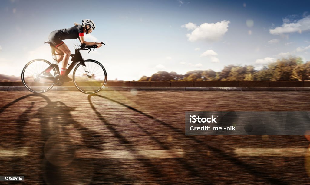 Sport. The cyclist rides on his bike at sunset. Dramatic background. Sport. Cycling Cycling Stock Photo