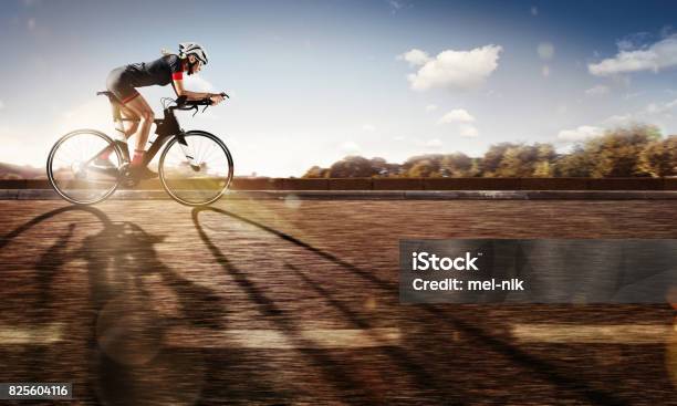 Sport The Cyclist Rides On His Bike At Sunset Dramatic Background Stock Photo - Download Image Now