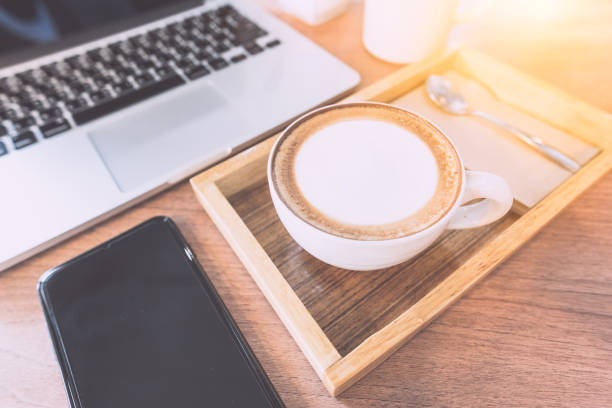 istock Hot Coffee or coffee cappuccino, Sugar, Mobile Phone and laptop computer On the working table in the morning. 825604382