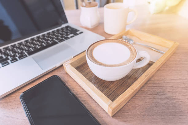 istock Hot Coffee or coffee cappuccino, Sugar, Mobile Phone and laptop computer On the working table in the morning. 825605260