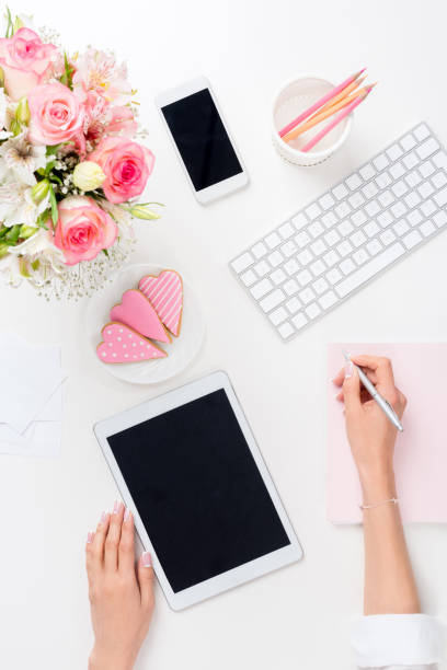 istock cropped show of woman using digital tablet and taking notes at workplace 825608272