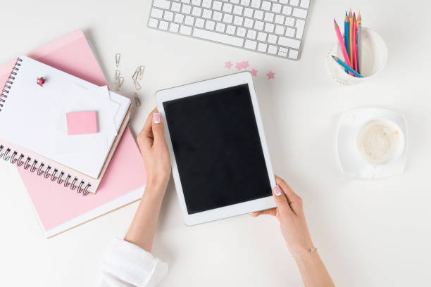 istock woman holding digital tablet with blank screen at workplace 825608492