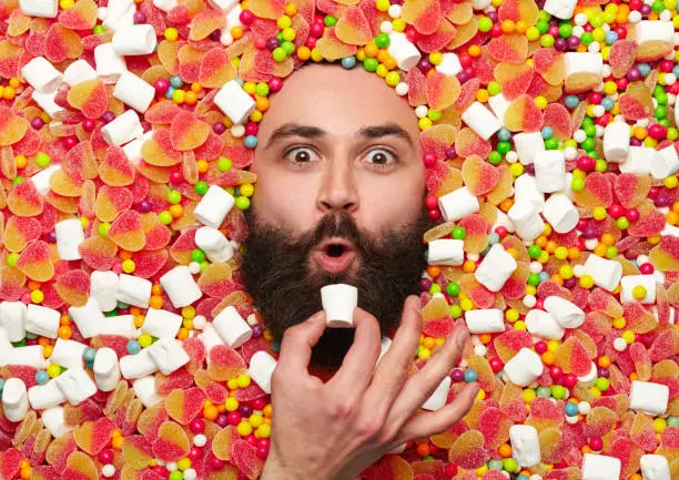 Photo of Bearded guy surrounded with sweet stuff