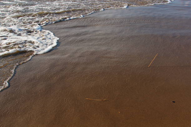 istock A background of a sandy beach with a receding wave 825616370