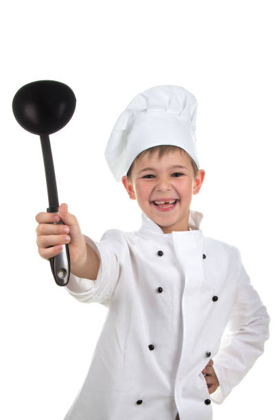 istock Happy little chef showing his black ladle on white background. 825616464