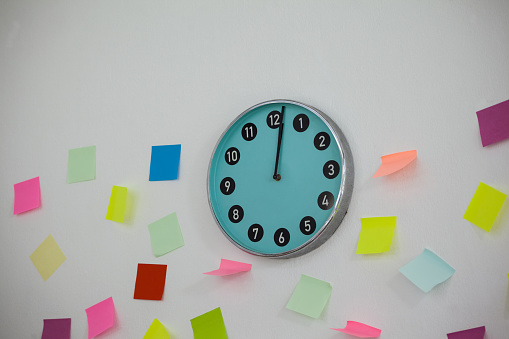 Colorful Sticky notes with clock on wall
