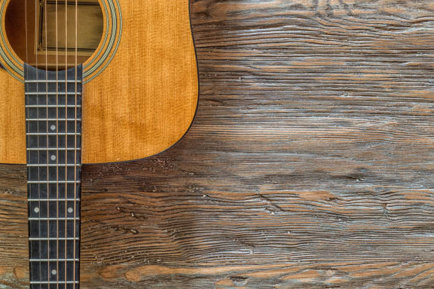 istock Acoustic guitar against a wooden background with copy space 825624016