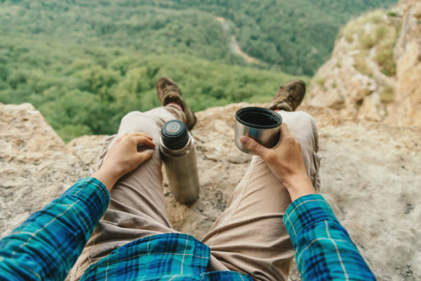 istock Traveler drinking tea from thermos. 825627670