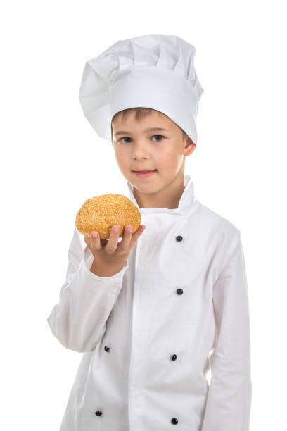 istock Small pretty chef holds delicious fresh sesame seed bun, on white background 825646658