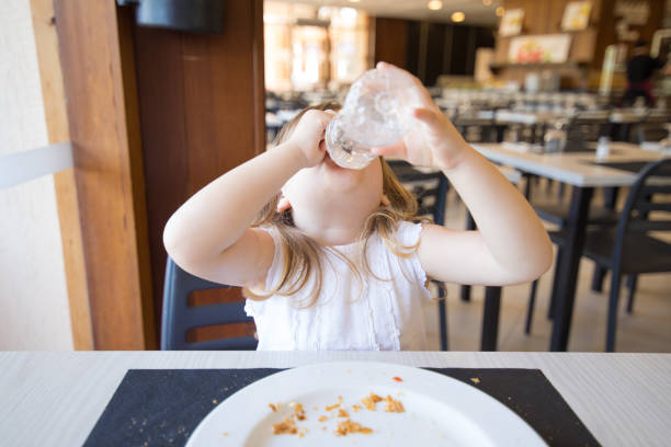 istock little child drinking from plastic bottle in hands 825651198