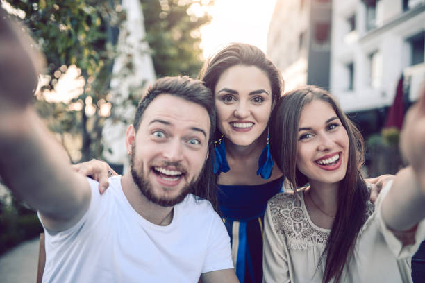 istock Young Smiling Friends Taking a Selfie in Coffee Shop 825654838