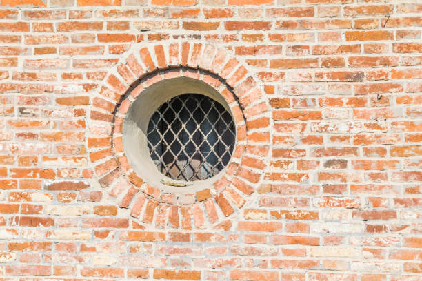 round window with grille on the brick wall