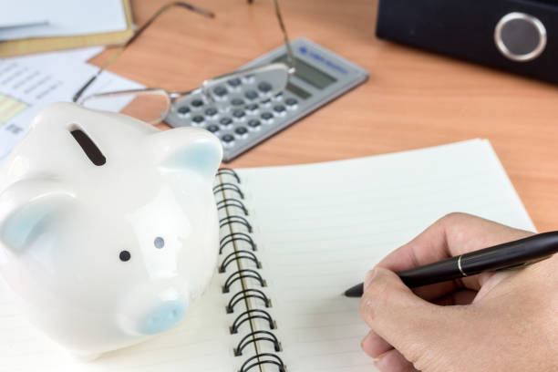 istock Piggy bank and calculator on business documents background 825658266