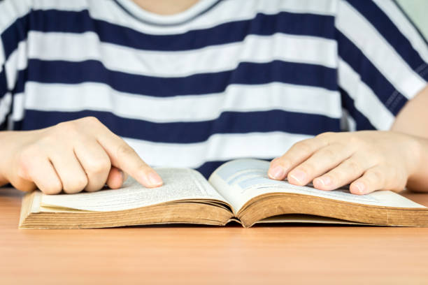 istock Woman reading book on the table 825658300