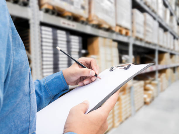 istock Man checking  list on clipboard in a warehouse 825658338