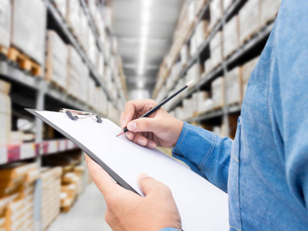 istock Man checking  list on clipboard in a warehouse 825658354