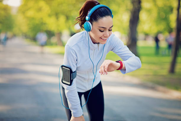 istock Running girl is checking her smart watch 825658862