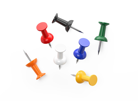 A set of scattered colorful push pins on white background. High angle view. Clipping path is included. Isolated on white background with copy space.