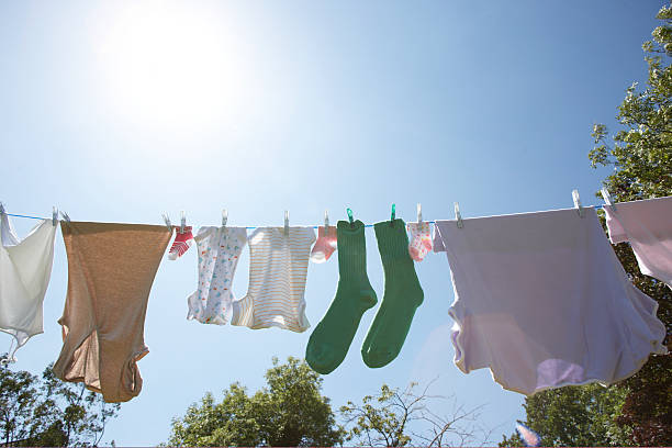 laver sur la ligne une paire de chaussettes vert - corde à linge photos et images de collection
