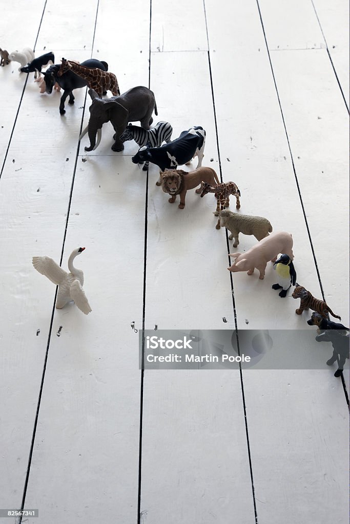 plastic toy animals lined up with swan in front  Leadership Stock Photo