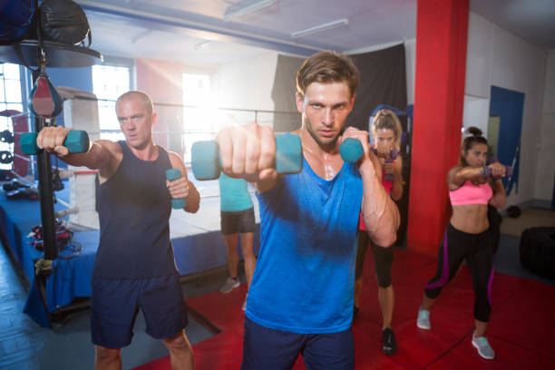 jóvenes atletas de perforación con pesas - healthy lifestyle men boxing dumbbell fotografías e imágenes de stock