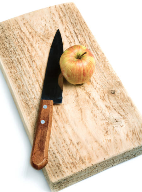 istock Knife and an apple on a cutting board isolated 825676078