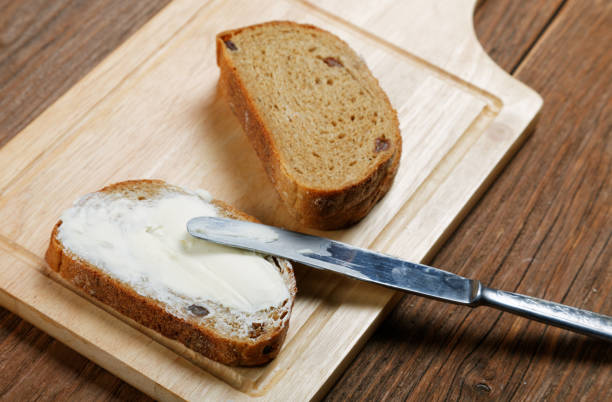 istock Sliced bread smeared with butter close-up 825676450