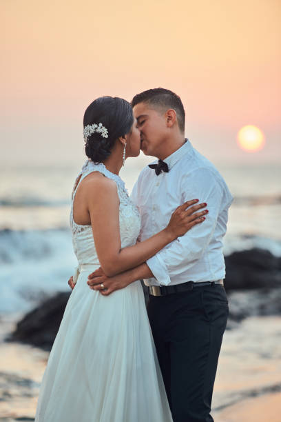istock Wedding couple kissing on beach 825685552