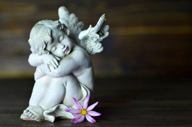 istock Angel guardian and  flower on wooden background 825700408