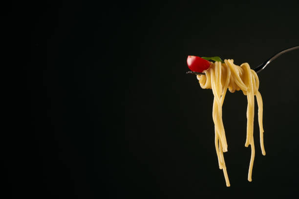 istock Closeup of a spaghetti on a fork. Girl keeping fork with spaghetti. 825701206