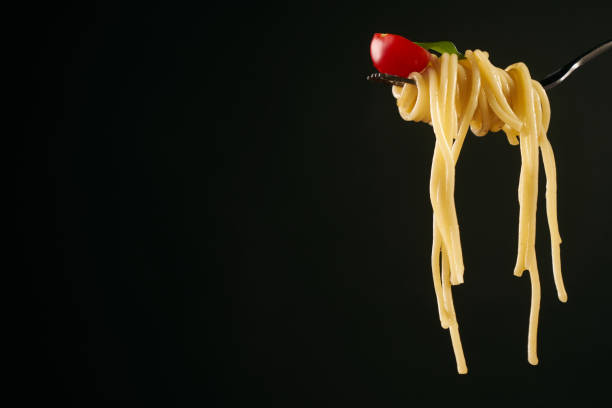 istock Closeup of a spaghetti on a fork. Girl keeping fork with spaghetti. 825704638