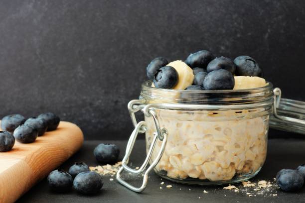 istock Overnight oats with blueberries and bananas against a dark background 825704960