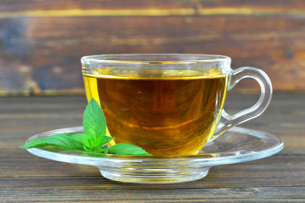 istock Mint tea in transparent glass cup on white background 825711484