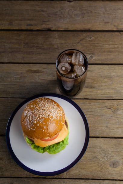 istock Hamburger in plate with glass of cold drink 825714550