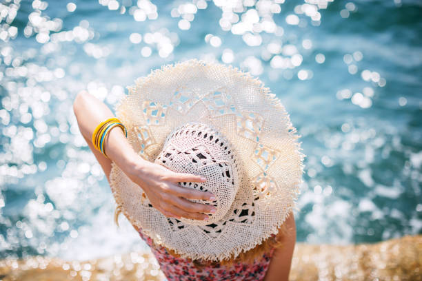 Woman with straw hat enjoying on sea pier