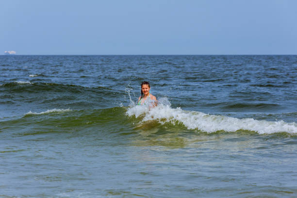 istock girl bathes in waves 825715494