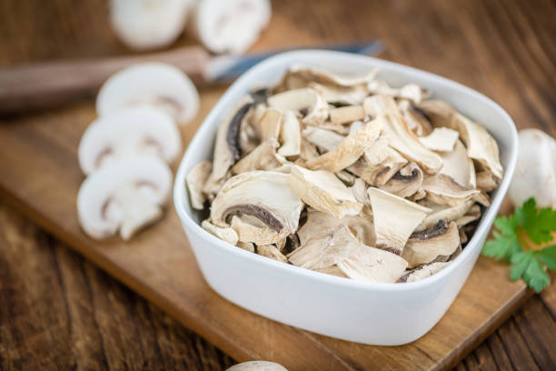 Dried Mushrooms (Agaricus) on an old wooden table as detailed close-up shot; selective focus