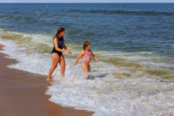 istock Two sisters swim in the ocean on waves 825721312