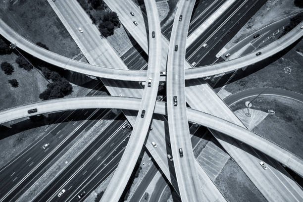 istock Curved highways and Interchanges and Overpasses aerial drone high above black and white Urban Sprawl 825722558