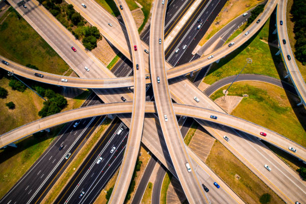 amber abstraite aérienne droit bas découvre courbe autoroutes et échangeurs et viaducs surplombant aériens drone - austin texas skyline texas cityscape photos et images de collection