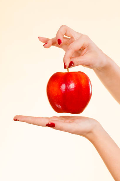 istock Woman hand holding delicious red apple 825729672