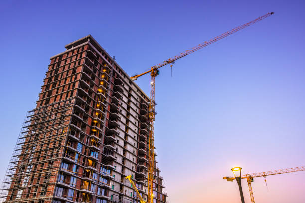 istock Crane at skyscraper construstion site at dusk 825733724