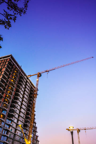 istock Crane at skyscraper construstion site at dusk 825733740