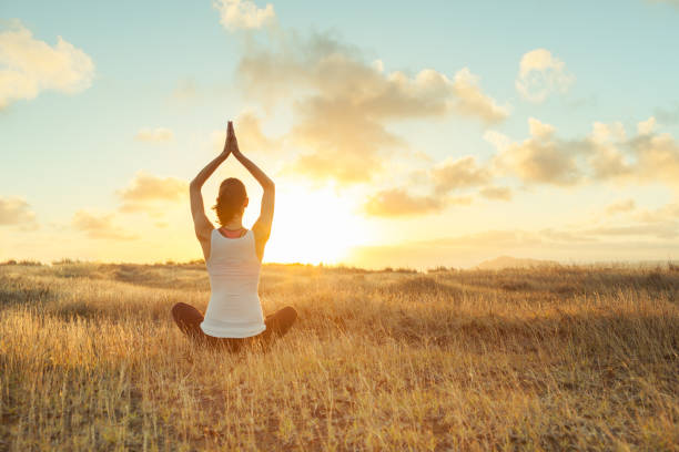 istock Woman doing yoga at sunset 825736712